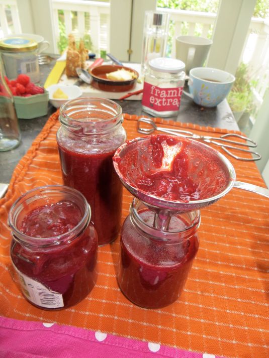 straining the fresh jam into sterilized jars